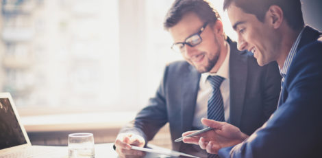 Discussing project Image of two young businessmen using touchpad at meeting
